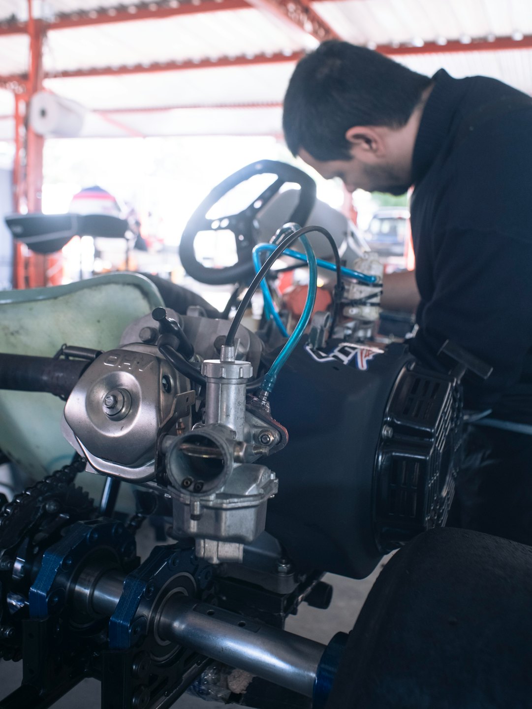 Mechanik pracujący nad silnikiem gokarta w warsztacie.